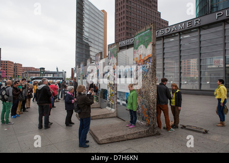 Touristen machen Fotos auf Überreste der Berliner Mauer am Potsdamer Platz Stockfoto