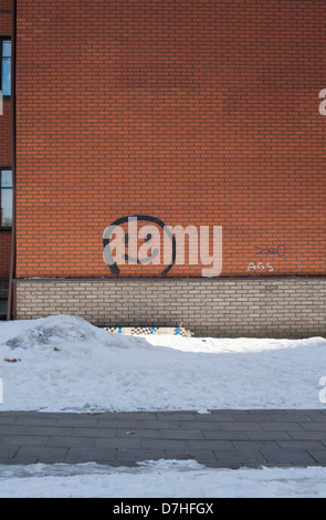 Ein Smiley auf einem Wohnblock in einem Vorort von Vilnius fallenden Schnee gemalt. Stockfoto