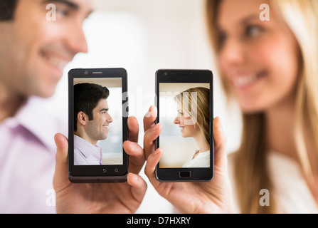 Paar Smartphones mit ihren Bildern festhalten Stockfoto