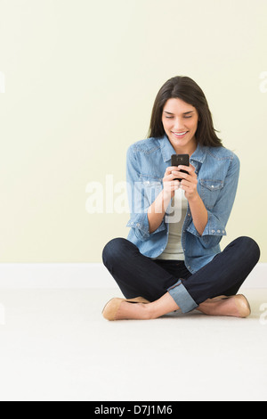Frau am Boden und mit Handy Stockfoto