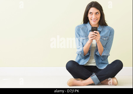 Frau am Boden und mit Handy Stockfoto