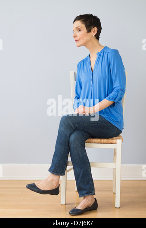 Porträt von Reife Frau auf Stuhl sitzend Stockfoto