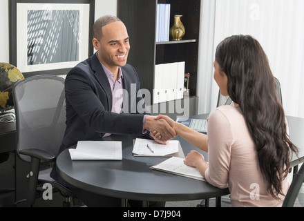 Mann und Frau Händeschütteln im Büro Stockfoto