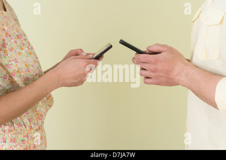 Junges Paar Kurzmitteilungen gleichzeitig Stockfoto