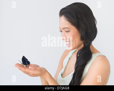 Junge Frau Holding Schmetterling Stockfoto