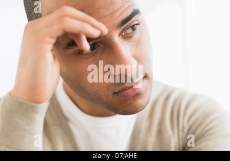 Porträt des jungen Mannes Kopf in Händen haltend Stockfoto
