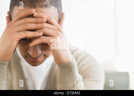 Porträt des jungen Mannes Kopf in Händen haltend Stockfoto