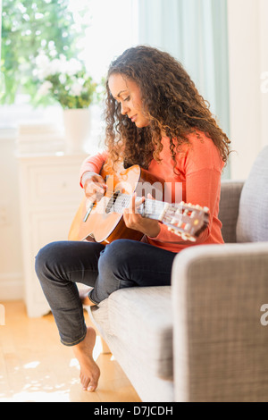 Junge Frau Gitarre spielen Stockfoto