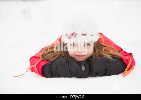 Porträt eines Mädchens (2-3) auf Schnee liegen Stockfoto