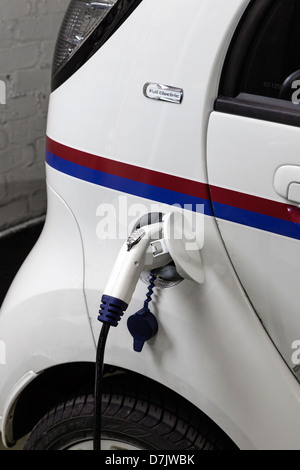 Elektro-Auto wird aufgeladen mit einem Punkt-Ladestecker an das Fahrzeug angeschlossen. Stockfoto