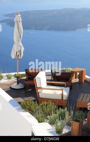 Gartentisch und Sofas auf der Terrasse mit Blick auf Meer in Santorin, Griechenland. Stockfoto