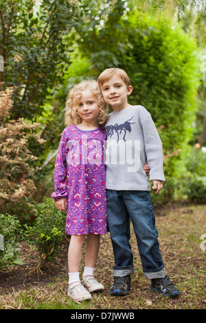 USA, Kalifornien, San Juan Capistrano, Bruder (6-7) und Schwester (4-5) posieren zusammen im Garten Stockfoto