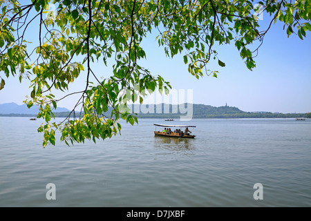 Touristen in traditionellen Ruderboote am West Lake Hangzhou Stockfoto