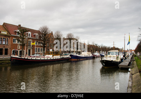 Ein Blick auf einen Kanal in Brügge, mit Boates und Lastkähne entlang des Kanals. Stockfoto