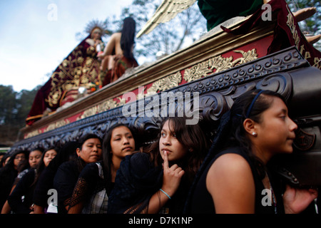 Frauen, die gekleidet mit traditioneller Kleidung tragen einen Thron während der Semana Santa in La Antigua Guatemala, 27. März 2013. Stockfoto