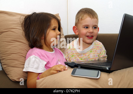 Bruder und Schwester, die gerade einer Geschichte über einen Computer. Stockfoto