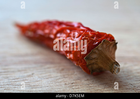 Natürlich beleuchteten Makro Bild eines Getrocknete ganze Chili, lag auf einem hölzernen Schneidebrett Stockfoto