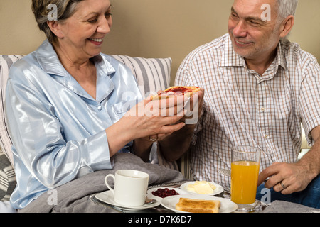 Älteres Paar mit romantisches Frühstück im Bett Stockfoto