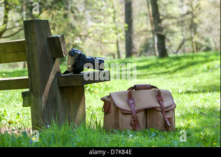 Nikon Kamera-Ausrüstung und Tasche auf einem Sitzplatz in einem englischen Waldgebiet Stockfoto