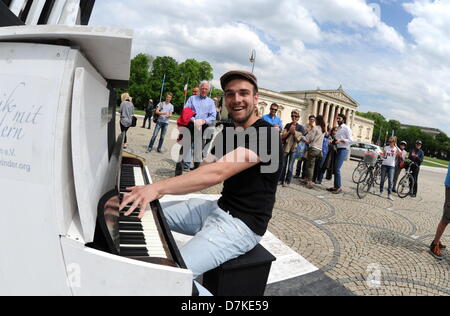 Barnabas Albrecht spielt Klavier, die im öffentlichen Raum im Rahmen des Kunstprojekts eingerichtet worden "spielen Me I 'm Yours auf Pinakothek mit der Glypothek im Hintergrund in München, Mai 09 2013. Dies ist einer der wenigen Straße Klaviere rund um München und soll die Kommunikation unter den Passanten zu fördern. Initiiert wurde das Projekt vom Künstler Luke Jerram. Foto: TOBIAS HASE Stockfoto