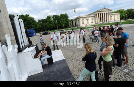 Barnabas Albrecht spielt Klavier, die im öffentlichen Raum im Rahmen des Kunstprojekts eingerichtet worden "spielen Me I 'm Yours auf Pinakothek mit der Glypothek im Hintergrund in München, Mai 09 2013. Dies ist einer der wenigen Straße Klaviere rund um München und soll die Kommunikation unter den Passanten zu fördern. Initiiert wurde das Projekt vom Künstler Luke Jerram. Foto: TOBIAS HASE Stockfoto