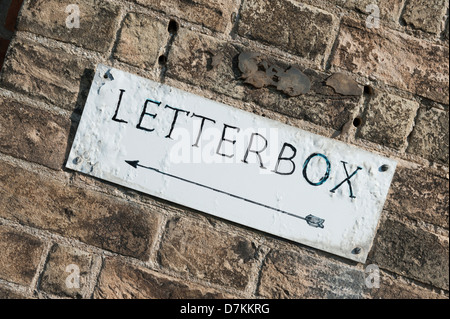 Ein Wegweiser in Richtung ein Briefkasten an einer Wand in Southwold, Suffolk UK Stockfoto