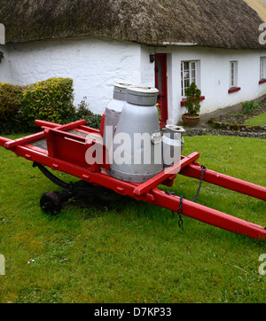 Milchkannen auf roten Wagen Adare Dorf strohgedeckten Limerick traditionelle Tradition attraktive Hüttendorf historische Stockfoto