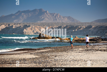 Cabo Pulmo, Mexiko, Bruder und Schwester zu Fuß auf einsamen Strand mit Gebirgshintergrund. (MR) Stockfoto