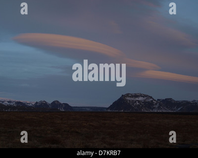 Linsenförmige Wolken bilden über isländische Berge Stockfoto