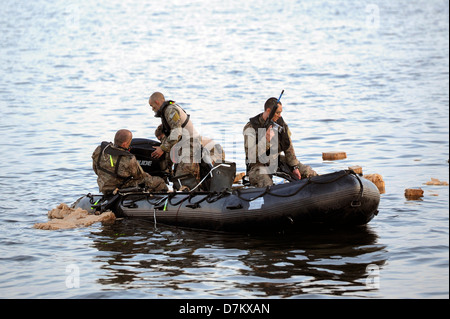 US Army Special Forces Soldaten montieren des Motors ein Zodiac-Boot für eine Ausbildungsmission 26. April 2013 in Hurlburt Field, FL. Stockfoto