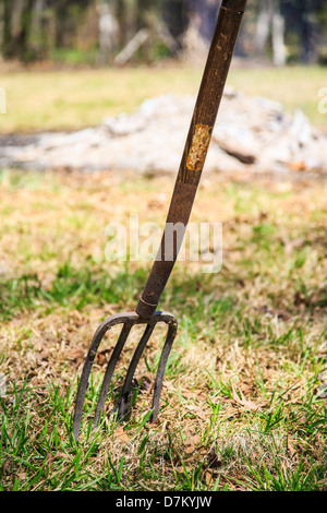 Eine Pitchgabel steht an einem Frühlingstag auf dem Bauernhof. Stockfoto