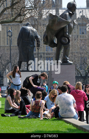 London, England, Vereinigtes Königreich. Menschen entspannen in Parliament Square - Statuen von Lloyd George und Churchill Stockfoto