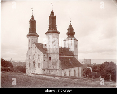Die Kathedrale von Visby befindet sich in der mittelalterlichen Stadt Visby, Gotland, Schweden, und ist ein Paradebeispiel gotischer Architektur. Dieses Foto, aufgenommen von Carl Curman, stellt die historische Struktur der Kathedrale mit ihrem heutigen Aussehen in Kontrast und unterstreicht ihre kulturelle und architektonische Bedeutung. Stockfoto