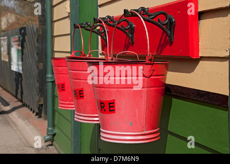 Nahaufnahme von drei traditionellen roten Feuereimern am Bahnsteig Pickering North Yorkshire England Großbritannien Großbritannien Großbritannien Großbritannien Großbritannien Großbritannien Stockfoto