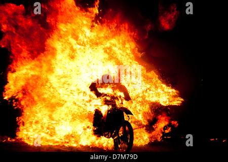 Stuntfrau Fahrt durch Feuerwand Stockfoto