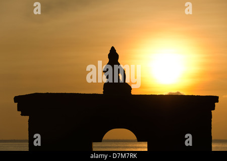 Silhouette von Sitzender Buddha auf Bogen gegen steigende Sonne und Orange sky Stockfoto