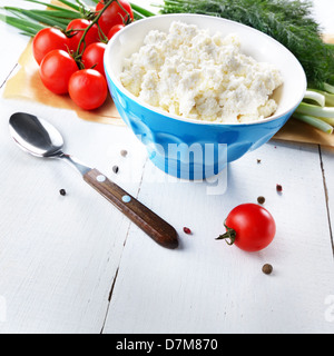 Hüttenkäse in blau Schüssel mit Tomaten Stockfoto