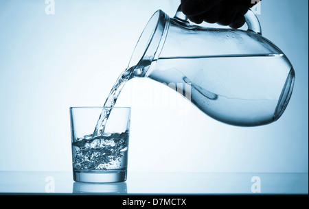 Wasser in ein Glas gießen Stockfoto