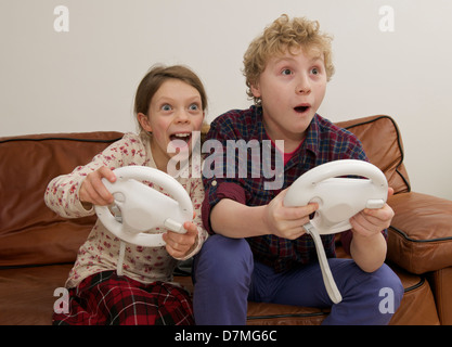 Jungen und Mädchen spielen auf interaktives Spiel in häuslicher Umgebung Stockfoto