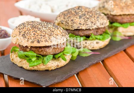 Gourmet-Hamburger - Burger in bestreute Brötchen und Sommer Blätter Stockfoto