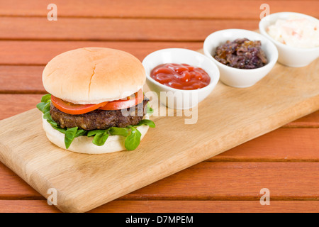 Buger mit Ketchup, karamellisierten Zwiebeln und Krautsalat. Stockfoto