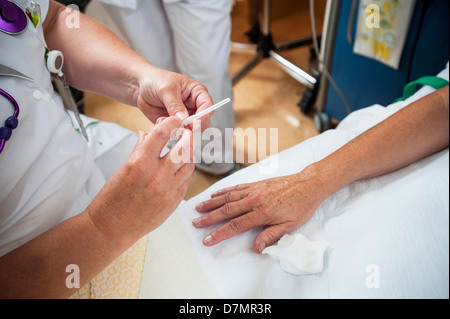 Krankenschwester, die Vorbereitung eines Patienten auf eine IV-Leitung Stockfoto