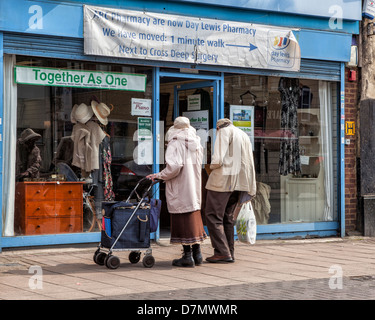 "Gemeinsam als eine" - älteres Ehepaar Blick auf waren im Fenster von einem Secondhand-Shop in einem leeren Speicher in Twickenham Stockfoto