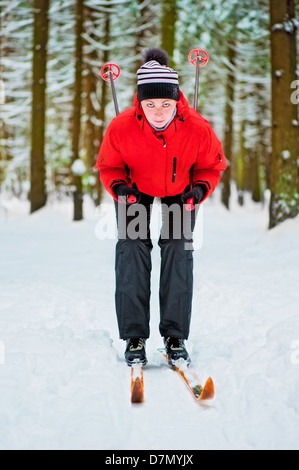 Glückliches Mädchen posiert auf Skiern in den Winterwald. Stockfoto