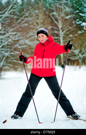 Glückliches Mädchen posiert auf Skiern in den Winterwald. Stockfoto
