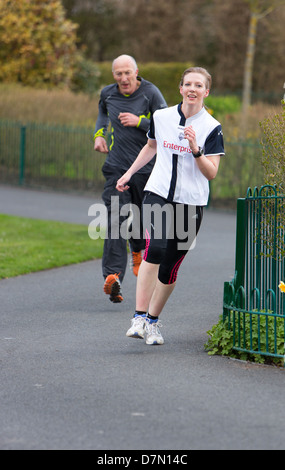 Läufer, die Teilnahme an den wöchentlichen Parkrun in Barrow Park Stockfoto