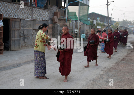 Eine Reihe von buddhistischen Mönchen erhalten Angebote von Reis Almosen von Einheimischen in der Nähe von Inle Lake Myanmar (Burma) Stockfoto