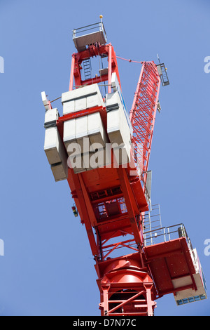 Ein Kran heben Betonblöcke an einem hohen Gebäude gebaut Stockfoto