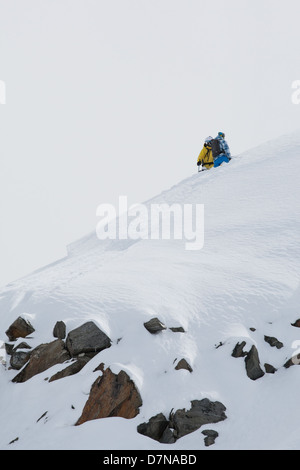 Ein Skifahrer und Snowboarder stehen auf der Spitze eines Stockfoto