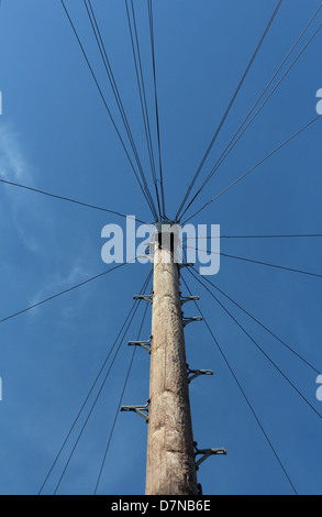 Telegrafenmast und Leitungen gegen blauen Himmel Stockfoto